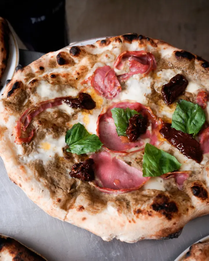 Pizza con mortadella, mozzarella e basilico